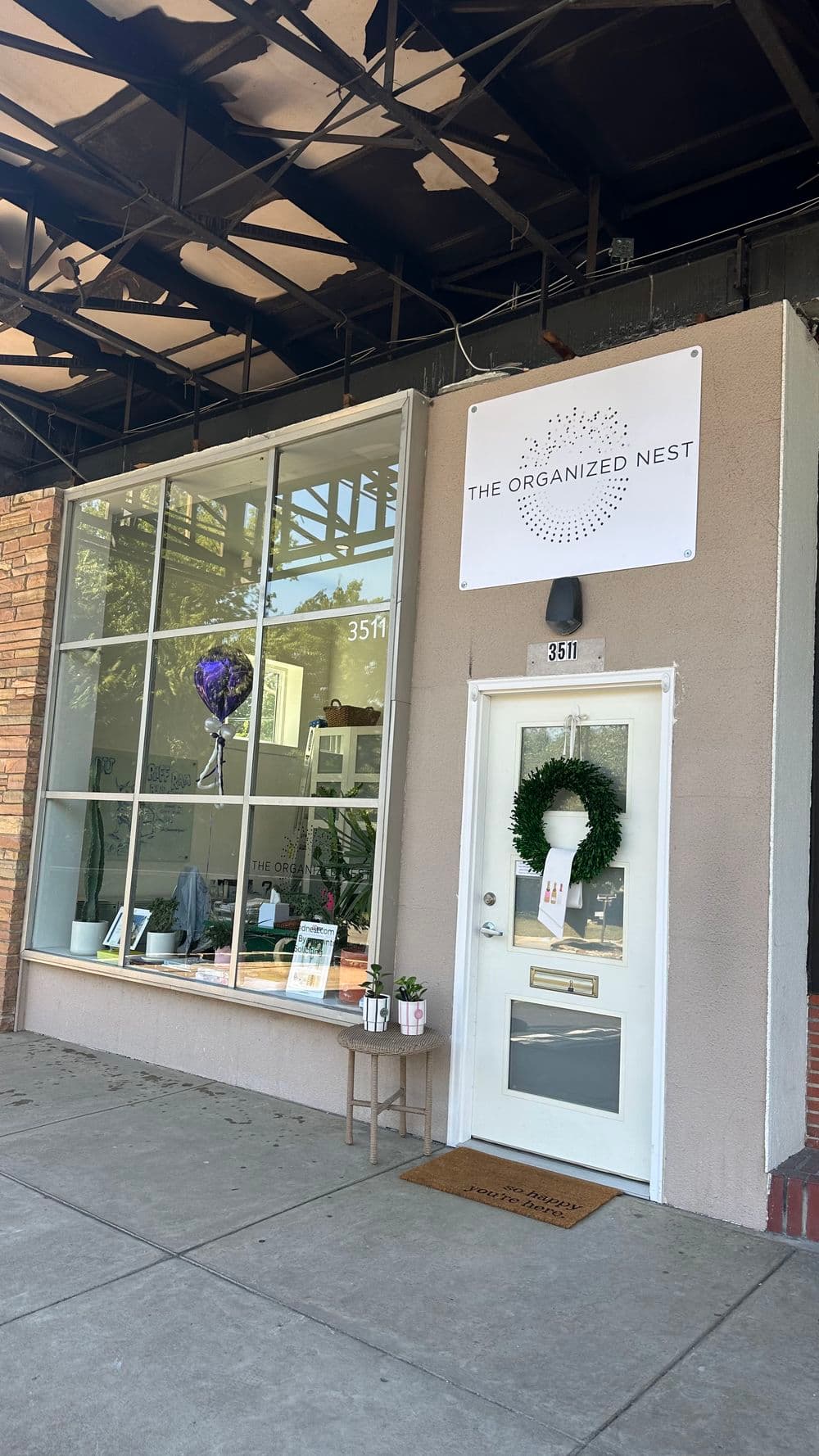 Storefront of The Organized Nest with large windows, wreath, and welcoming entrance.