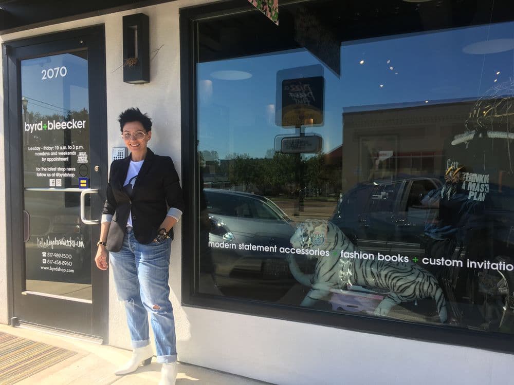 Person standing outside Byrd Bleecker boutique, showcasing modern fashion and accessories.