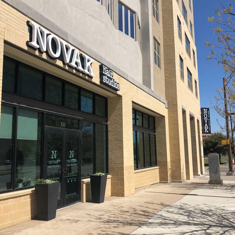 Novak Hair Studios storefront with modern architecture and clear signage in bright daylight.