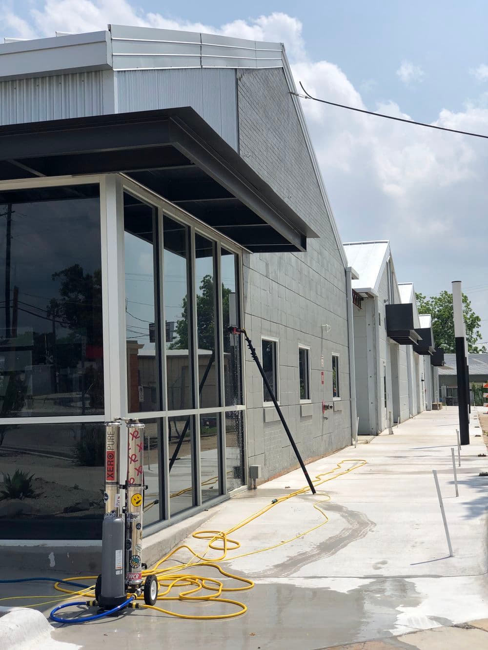 Modern commercial building exterior with large windows and construction equipment.