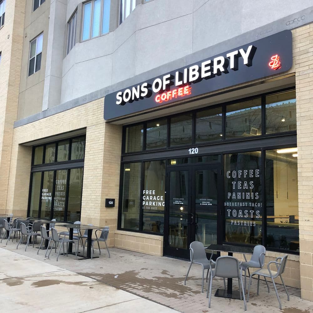 Sons of Liberty Coffee shop exterior with outdoor seating and parking details.