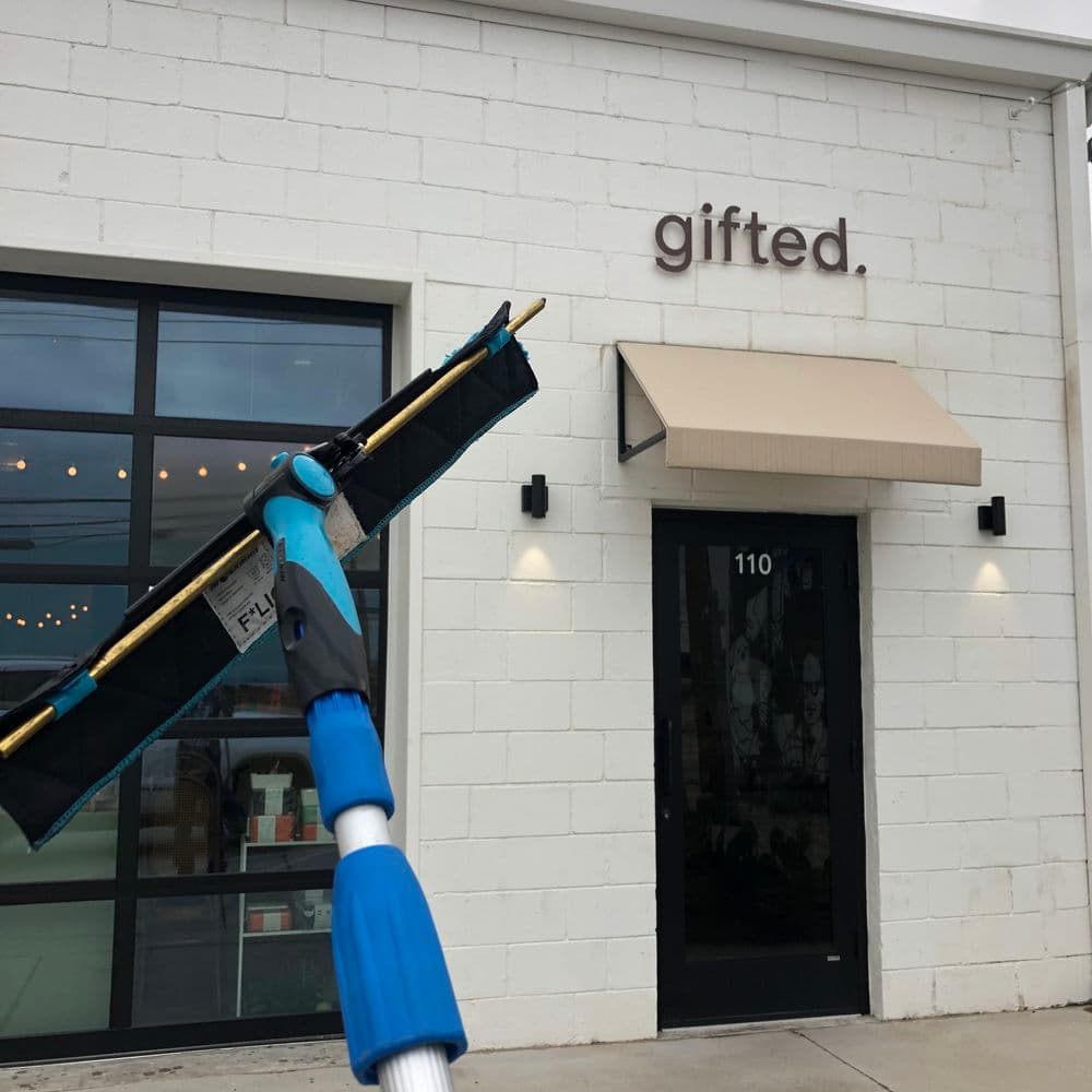 Exterior of "gifted." store with a cleaning tool in the foreground, showcasing modern design.
