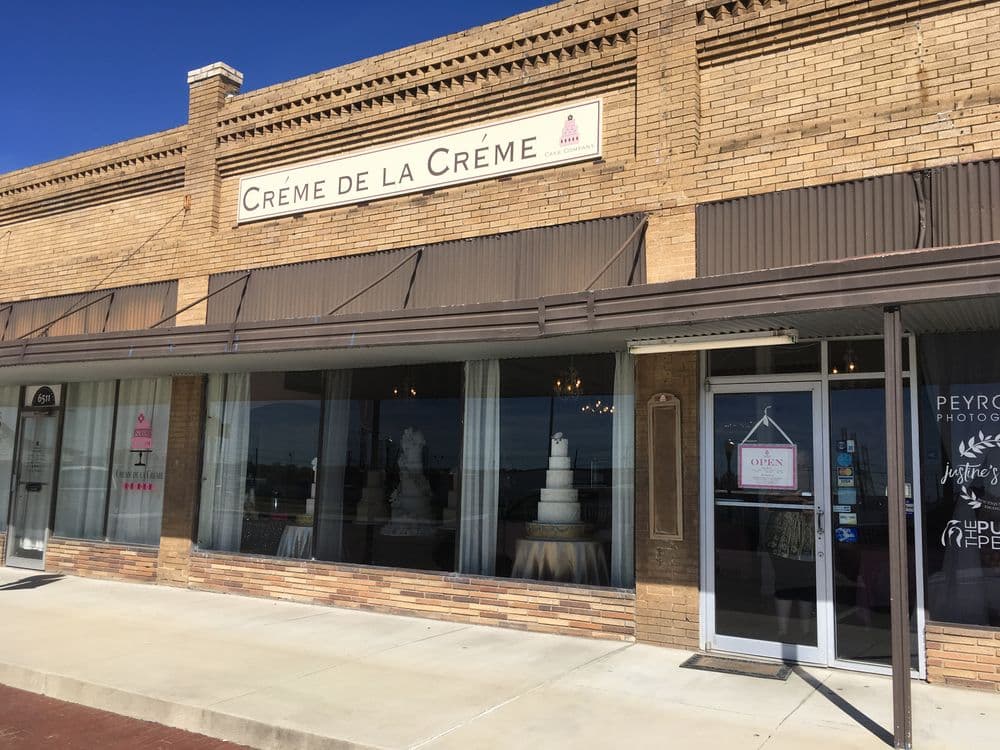 Bakery storefront "Crème de la Crème" featuring elegant wedding cakes and open sign.