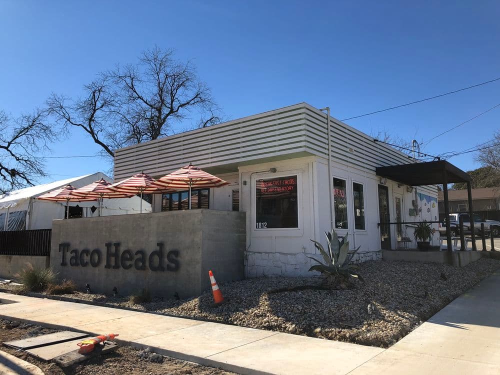 Taco Heads restaurant exterior with outdoor seating in bright sunny weather.