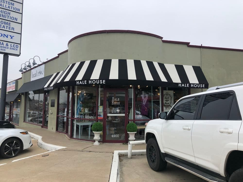 Hale House storefront with black and white striped awning and parked vehicles.