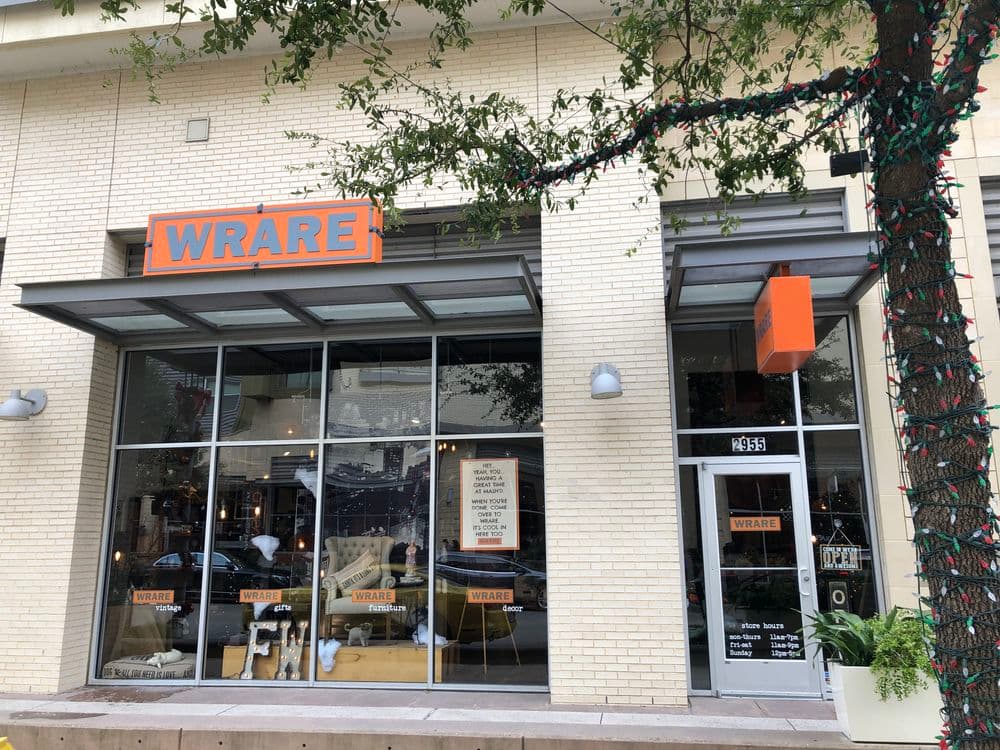 WRARE store facade with large windows and orange signage in a city setting.