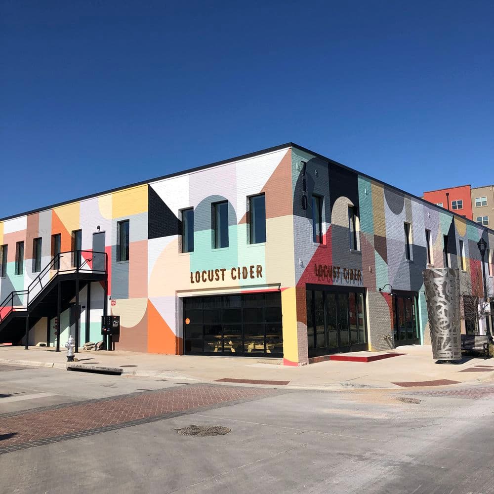 Colorful mural on Locust Cider building, showcasing vibrant design and inviting atmosphere.