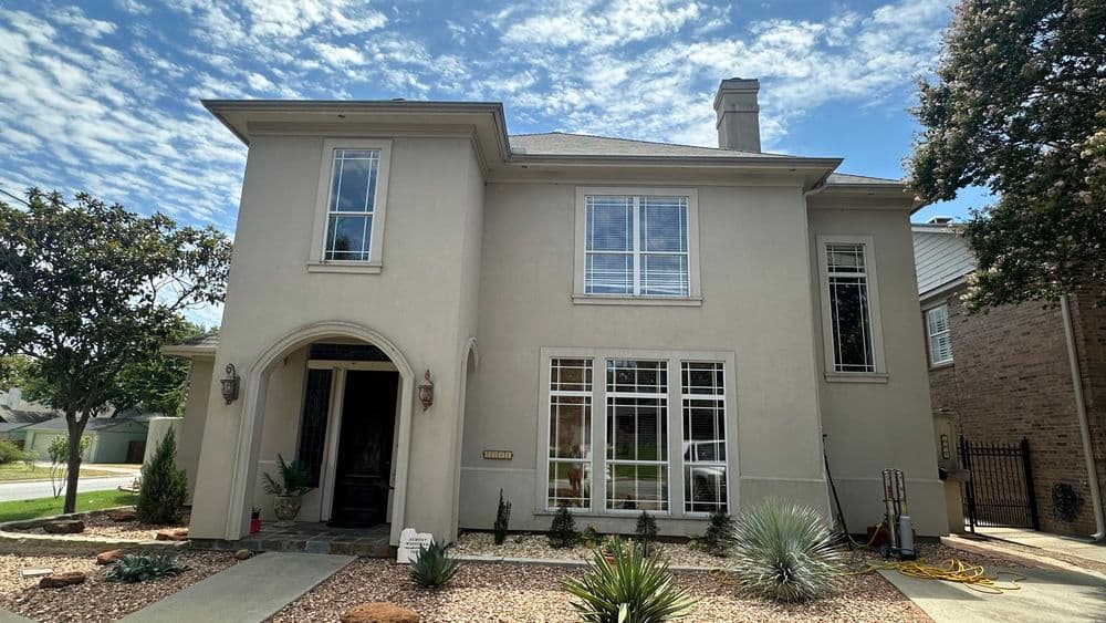 Elegant two-story home with modern architecture, large windows, and landscaped front yard.