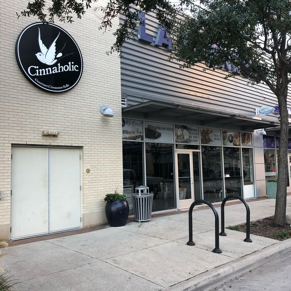 Cinnaholic store exterior with signage, featuring a modern design and bike racks outside.